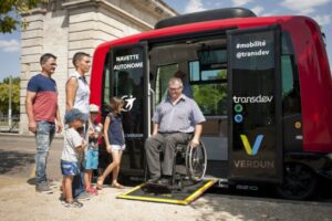 a man in a wheelchair gets out of a minibus